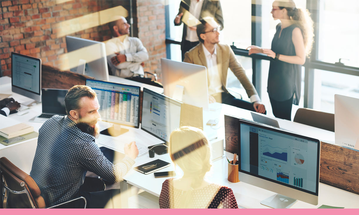 A group of coworkers in an open plan office.