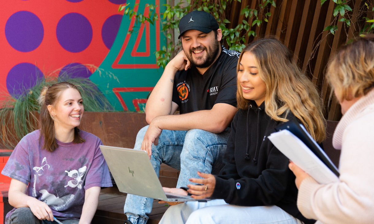 Group of students sitting outdoors on campus 