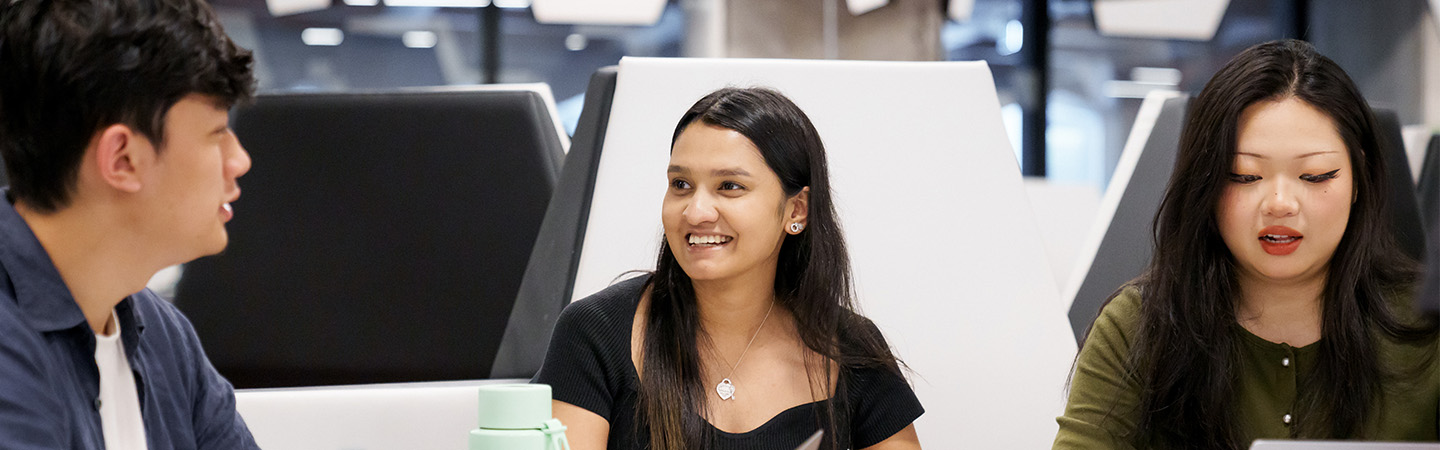 Close-up shot of hands pressing down pages of a RMIT brochure